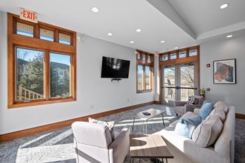 A living room with a couch, chair, and television.